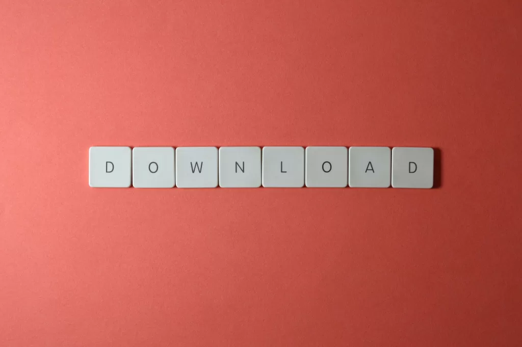 Minimalist photo of keyboard tiles spelling 'DOWNLOAD' on a red background.